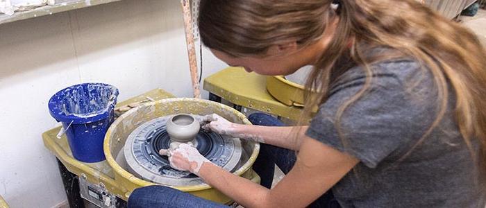 image of student working on a pottery wheel